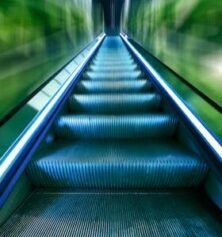 A vibrant, futuristic view of an escalator captured with dynamic motion blur, emphasizing speed and movement.
